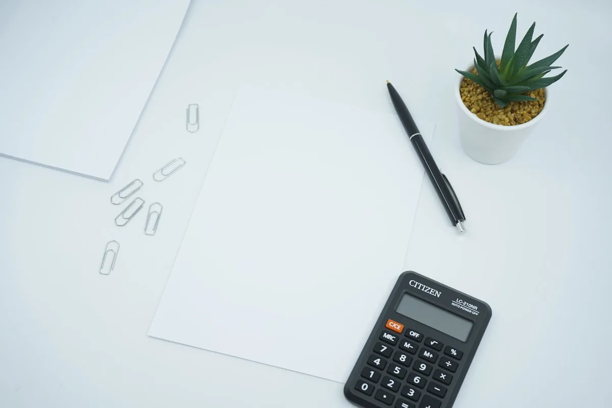 A desk with paper and a calculator